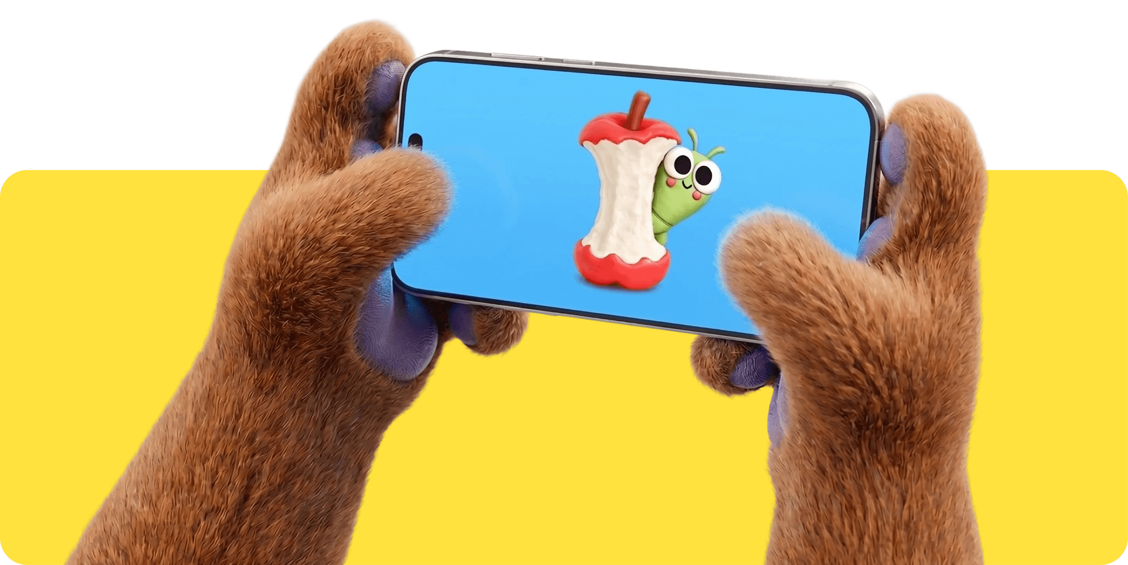 Bear stuffed animal hands holding a phone and watching content of a worm coming out of an apple.